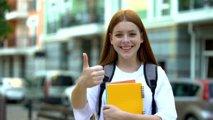 微笑的大学女生，字帖显示出竖起大拇指，对课程感到满意