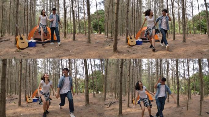 亚洲年轻夫妇在松树林中跳跃和享受露营