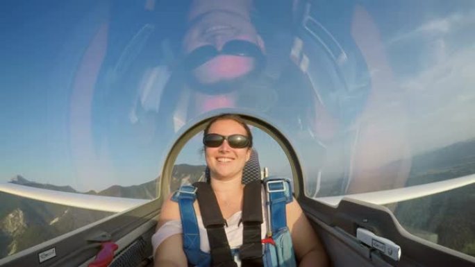 LD年轻女子在阳光明媚的天空中坐在高空滑翔机后面微笑