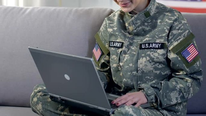 快乐的女军人通过在线应用和技术与家人的笔记本聊天