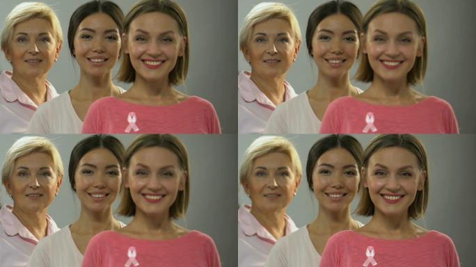 不同年龄的女性带着粉色丝带对着镜头微笑，乳腺癌控制