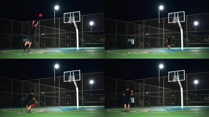 运动概念: 一个晚上独自在室外球场上打篮球的人。