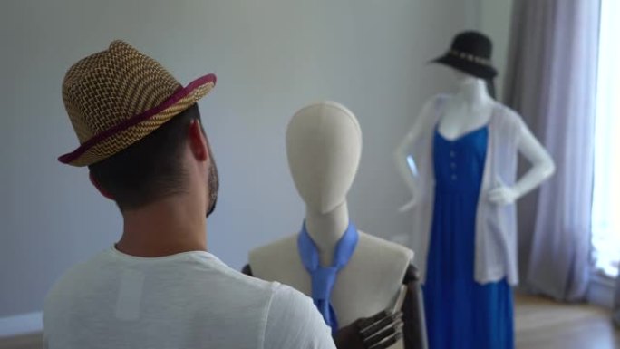 年轻人把帽子戴在头上看着男性模特的后视图。