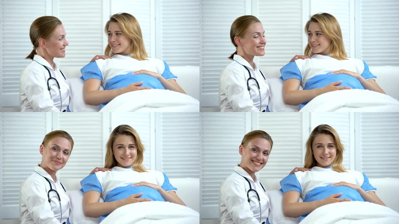 微笑的产科医生和孕妇抱着肚子看着相机