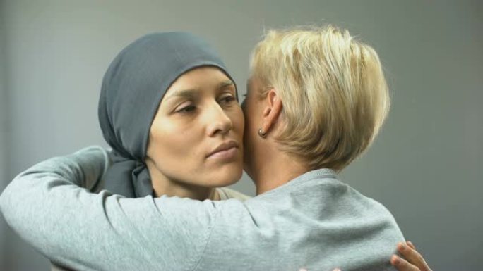 戴着头巾的沮丧妇女拥抱母亲，癌症治疗，诊断
