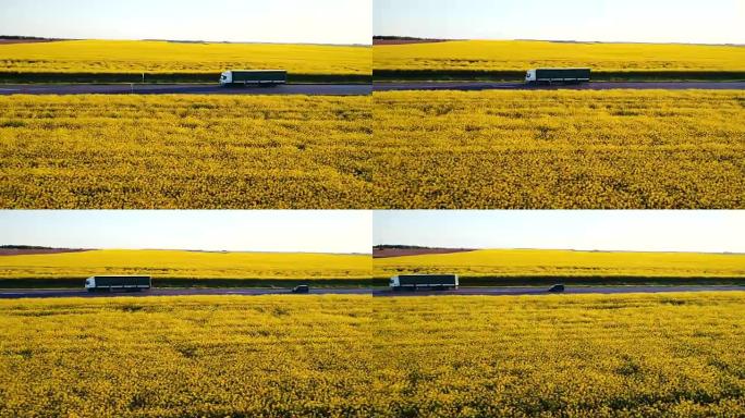 油菜籽黄田附近高速公路上卡车的鸟瞰图
