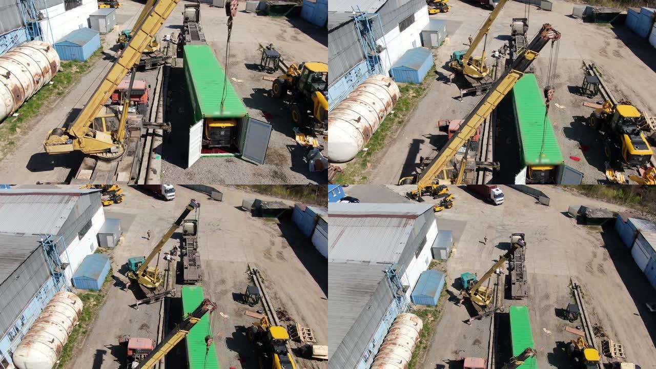 摄像机在第三世界国家的工业工厂上移动。绿色运输集装箱和黄色起重机，工人在施工现场行走。工业、商业。