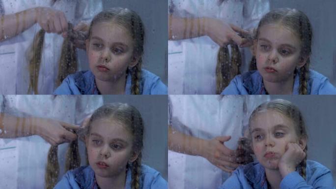 医务人员编织不舒服的女孩头发，孩子在医院里想家