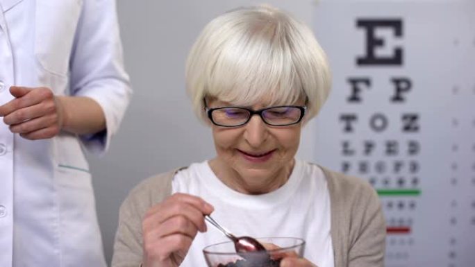 眼科医生为退休的女性患者提供蓝莓，有机维生素