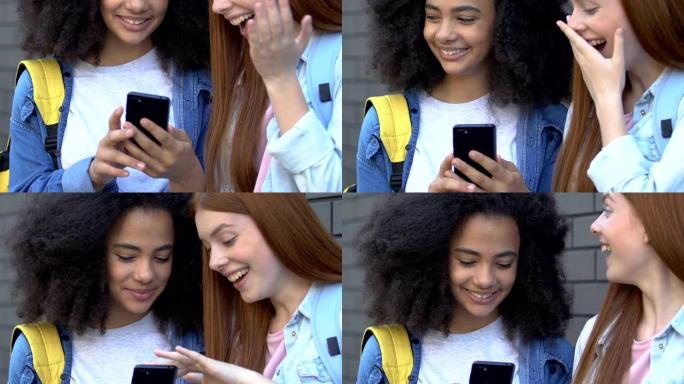 残酷的女学生使用电话在社交网络中嘲笑朋友，网络欺凌