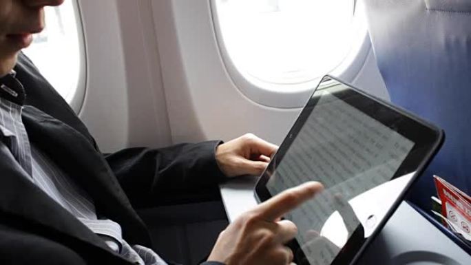 商人在飞机上使用平板电脑