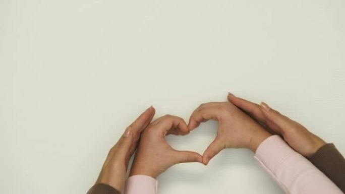 母亲和孩子的手，爱与关怀，家庭支持所显示的心脏形状
