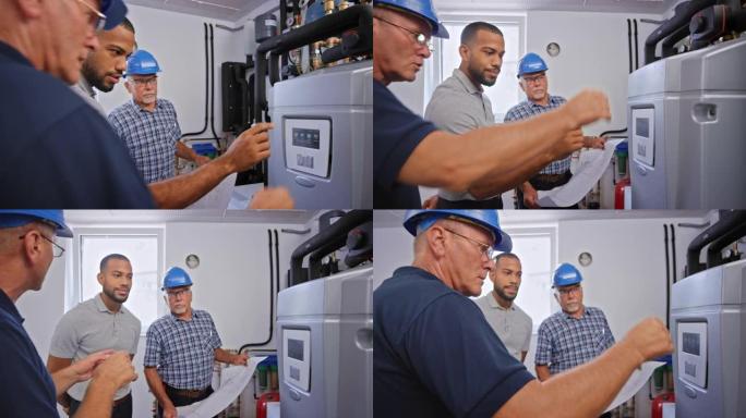 供暖工程师向男性业主解释中央供暖控制面板上的功能