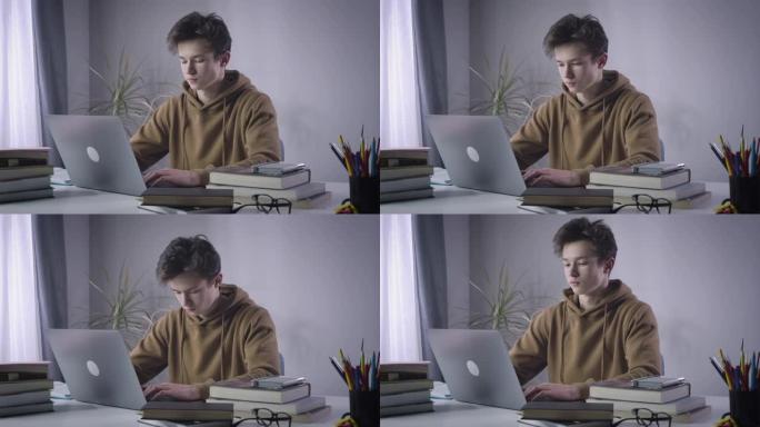 疲倦的男孩在笔记本电脑键盘上打字时与睡眠作斗争。精疲力竭的大学生在网上学习时睡着了。无线教育，生活方