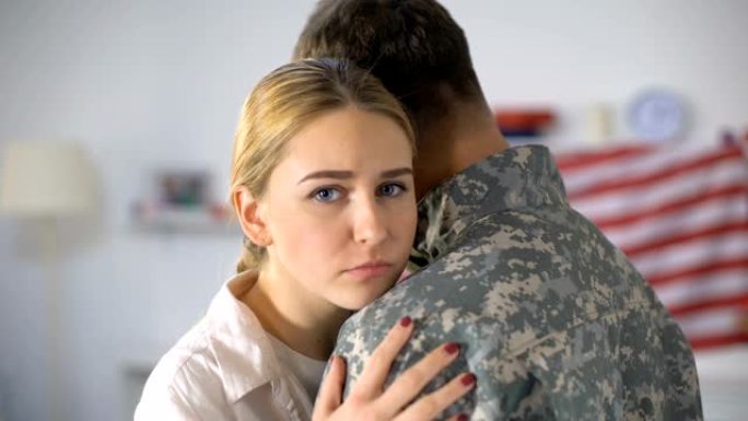 悲伤的女人拥抱着离家的士兵，在服兵役前告别