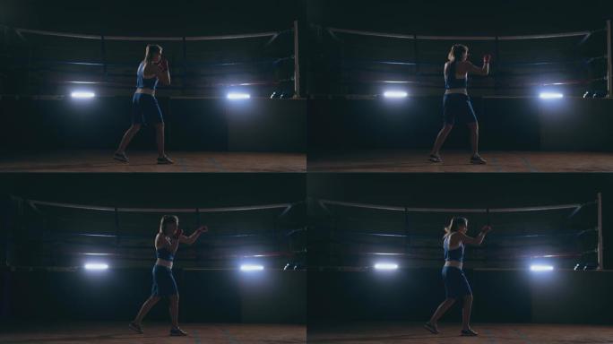 美丽的女拳击手在健身房锻炼时与影子进行搏斗。慢动作。steadicam射击