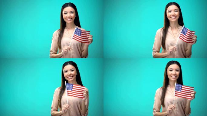 快乐的女孩举着美国国旗，准备学习外语，英语学校