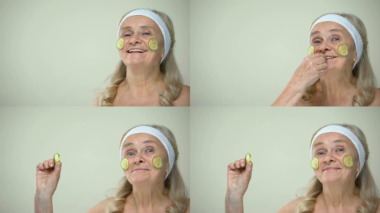 有趣的快乐奶奶，脸上戴着黄瓜面膜，咬着一片，微笑着