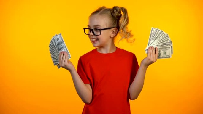 可爱的快乐女孩展示着一大笔现金，神童获奖奖金，收入