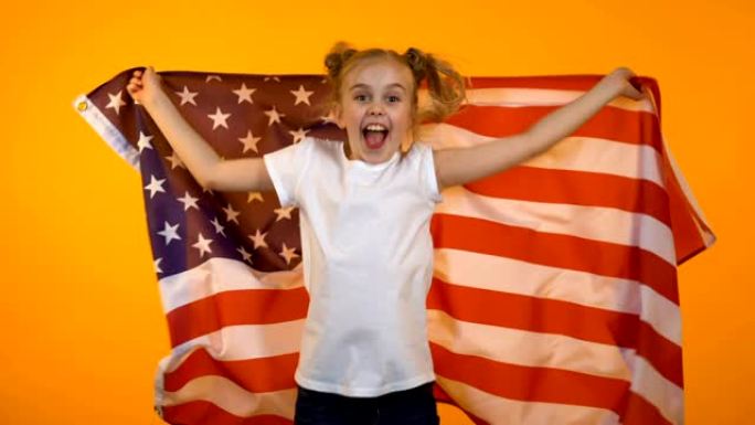 快乐的漂亮少女跳着美国国旗，为最喜欢的球队欢呼