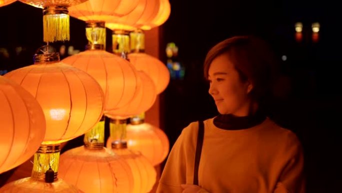 女人为庆祝中国春节而游灯