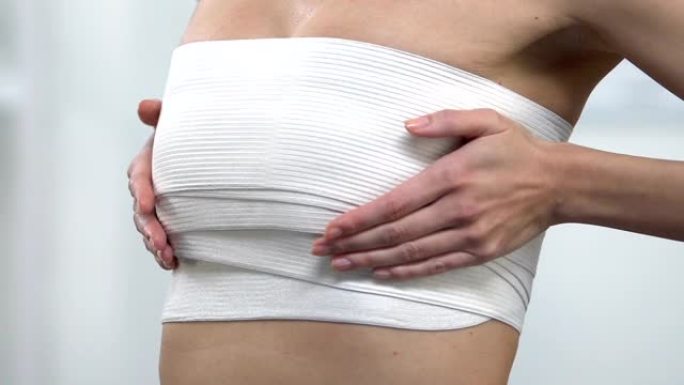 女性胸部按压包裹触摸胸部，乳房成形术手术结果