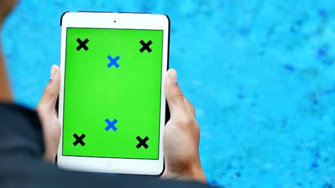 游泳池附近的绿屏平板电脑
