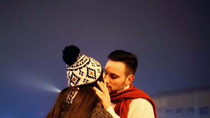 情侣在冬夜接吻。问