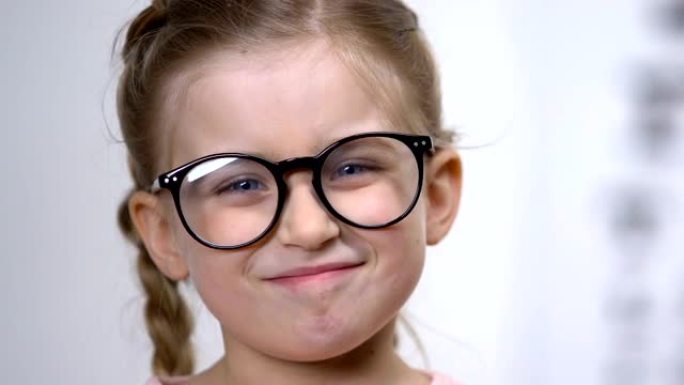可爱的微笑女孩调整眼镜，聪明的孩子，女学生，教育