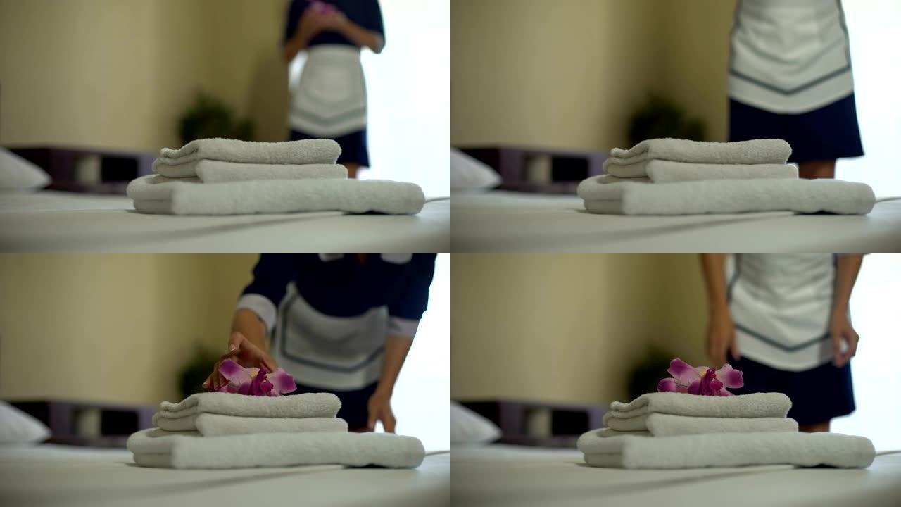 女服务员把芬芳的花放在干净的白色毛巾堆上，家政