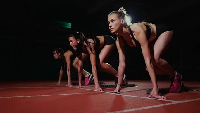 女运动员在比赛前在跑道上热身。慢动作