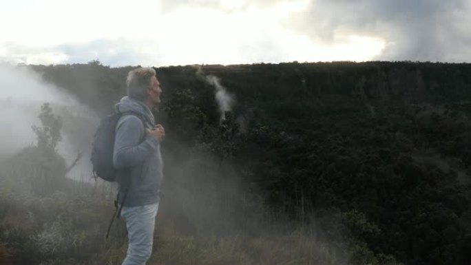 男子穿着背包走进火山景观