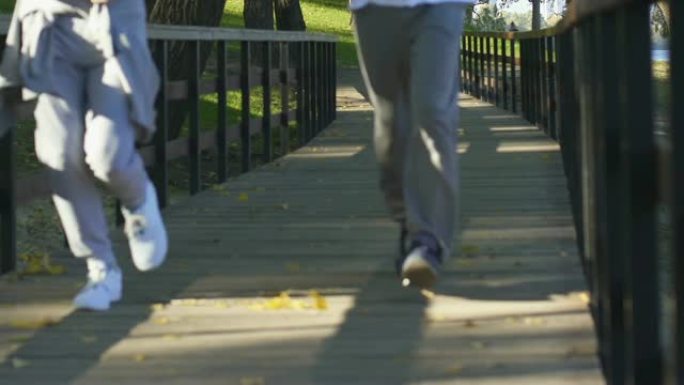 两个男性朋友沿着木桥慢跑，健康的生活方式，有氧训练