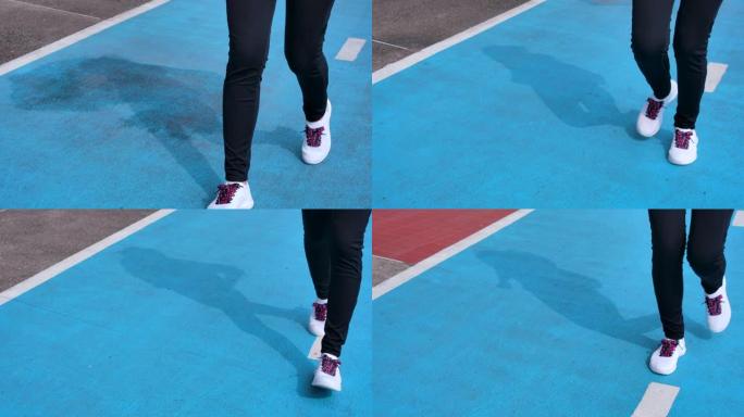 Slo运动女子在体育场的蓝色跑道上奔跑