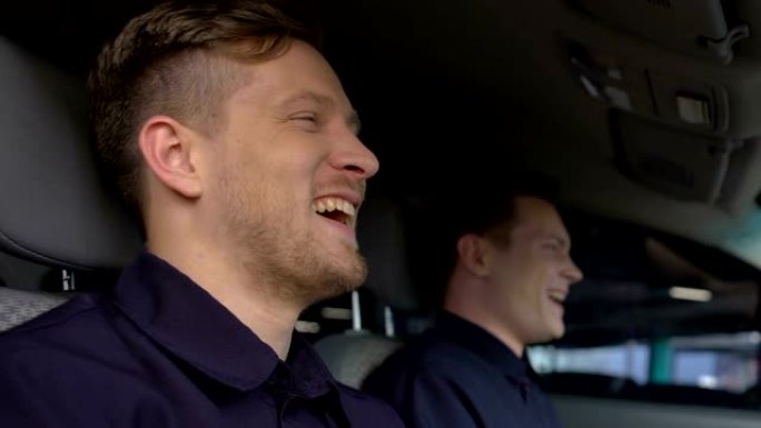 笑口常开的警察坐在巡逻车里，友谊在工作中，警察