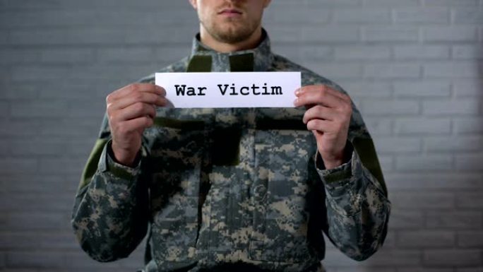 战争受害者的单词写在男性士兵的手上，精神障碍，创伤