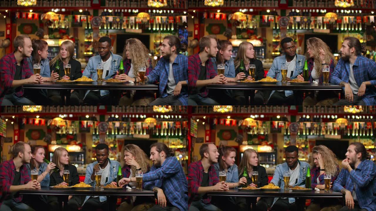 多种族的年轻男女在酒吧喝啤酒，并就大学进行有趣的讨论