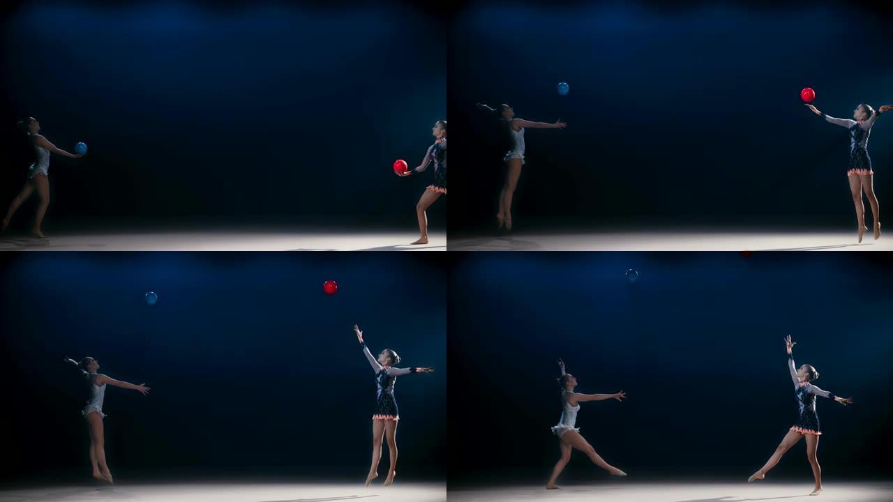 SLO MO LD两名艺术体操运动员朝相反的方向移动，并将球高高抛向空中