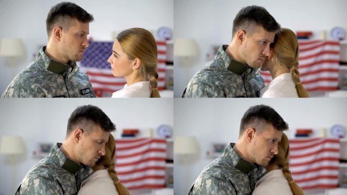 悲伤的美国士兵拥抱挚爱的妻子，在服兵役前告别