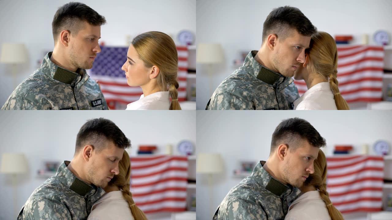 悲伤的美国士兵拥抱挚爱的妻子，在服兵役前告别