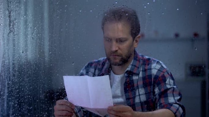 伤心男子在雨窗后读信，银行信贷付款逾期，贫困