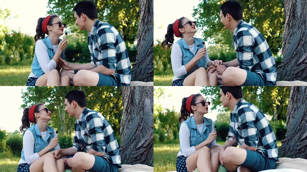 笑女孩和她的男朋友在公园野餐时放松