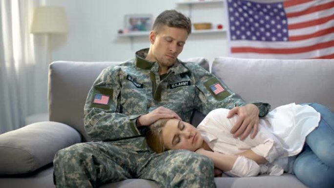 心烦意乱的美国士兵抚摸着睡在沙发上的女友，服兵役