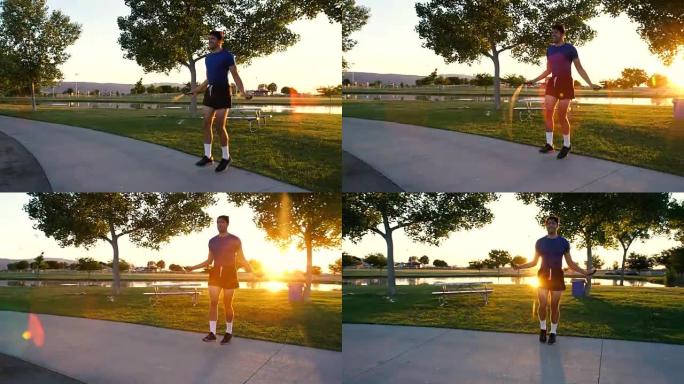 英俊的年轻运动员黄昏在公园跳绳