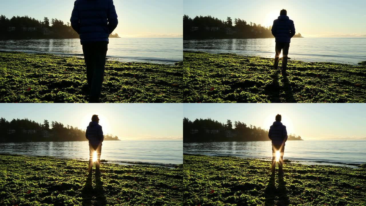 日出时，男子沿着海带海滩散步