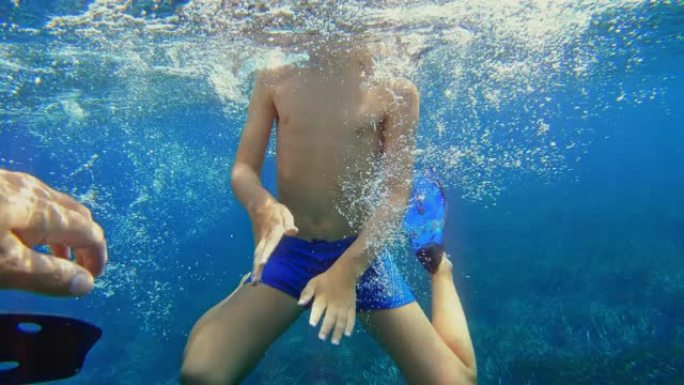 水下射击: 男孩在晴天在海滩附近浮潜