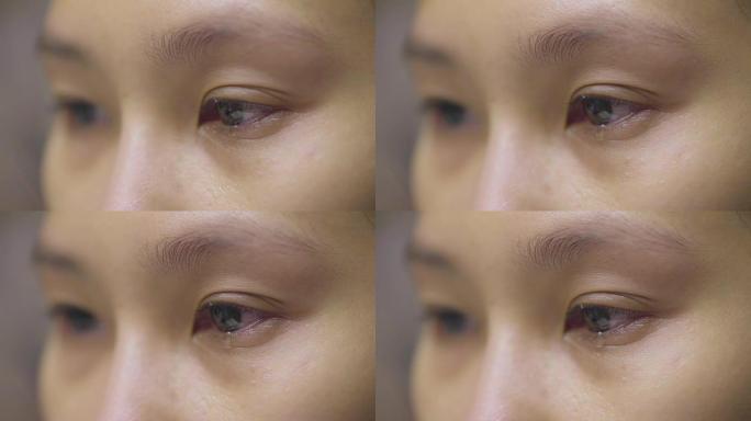 特写: 眼泪从眼睛中流出，并在脸颊上条纹。悲伤受虐的棕色眼睛哭泣的女性，亚洲模特。