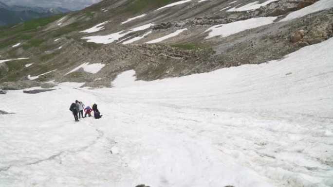 徒步旅行者等待着那个人从白雪皑皑的风景上滑下来
