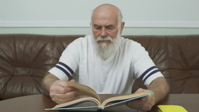 体贴的大胡子成年男子在看书。