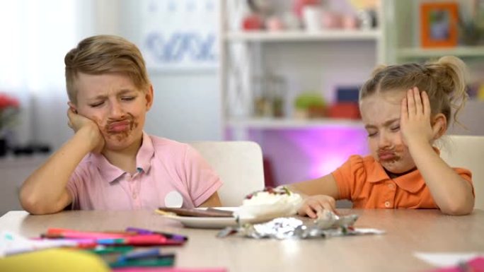 两个孩子涂抹巧克力坐桌，胃痛，暴饮暴食